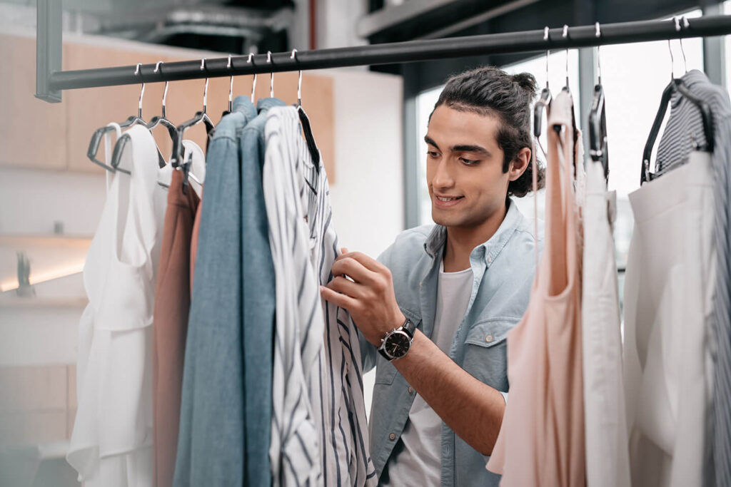 Man in store looking at shirts on a clothes rack