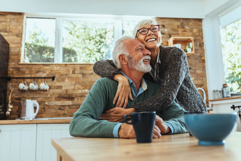 Older couple in kitchen hugging