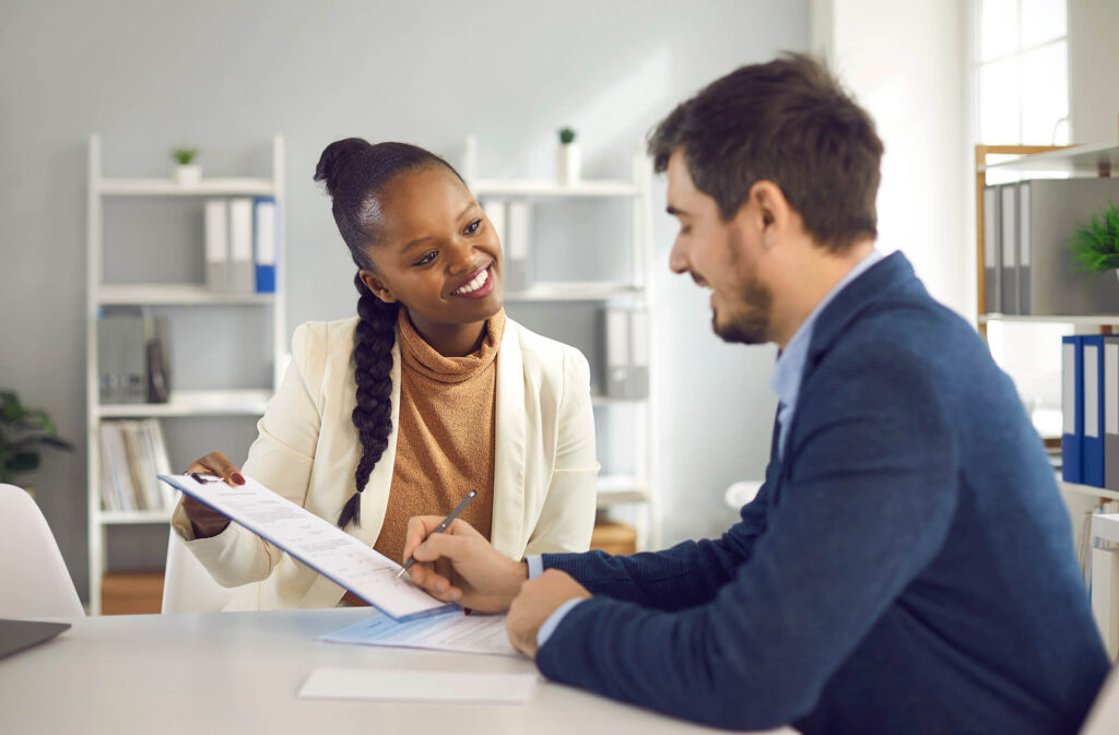 Business person signing business insurance policy with a Quaint Oak Insurance agent