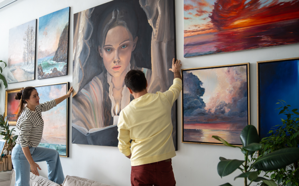 two people with a large art collection in their home add a new piece to their gallery wall protected with personal article floaters