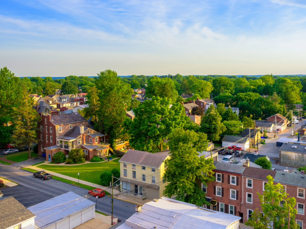 Aerial view of a tree-lined Philadelphia-area neighborhood with brick homes, representing local insurance services for homeowners and residents